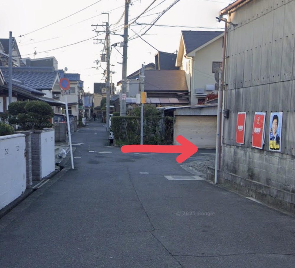住宅街の道で、矢印の先を右手に入る地点の写真
